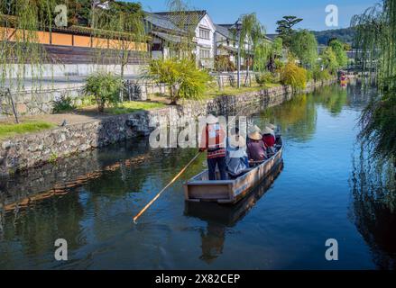 Quartiere storico di Kurashiki, con una barca che percorre il fiume in una giornata di sole, Giappone Foto Stock