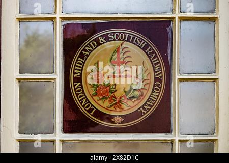 London, Midland and Scottish Railway Company cartello su una finestra, Ribblehead Station, Settlement to Carlise line, Inghilterra, Regno Unito Foto Stock