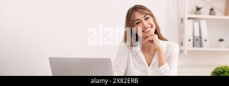 Donna imprenditrice di successo seduta su un laptop nell'ufficio moderno Foto Stock