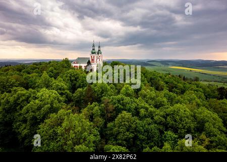 Chiesa barocca Poutni kostel Panny Marie Sedmibolestne su una collina Cvilin a Krnov, Repubblica Ceca, circondata da alberi in tempesta Foto Stock