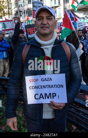 Londra, Regno Unito - 11 novembre 2023: Un manifestante con un cartello del campo di concentramento Stop Gaza alla manifestazione di protesta pro-palestinese nel centro di Londra, Regno Unito. Foto Stock