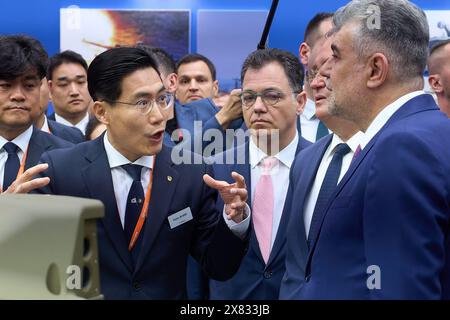 Bucarest, Romania. 22 maggio 2024: Peter Bae (L), Amministratore delegato Hanwha Q CELLS, parla con Marcel Ciolacu (R), presidente del Partito Social Democratico (PSD), durante la fiera internazionale 2024 della difesa del Mar Nero, Aerospazio e sicurezza (BSDA), al ROMAERO. Crediti: Lucian Alecu/Alamy Live News Foto Stock