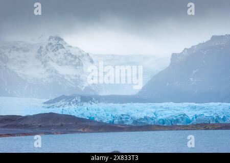 Iceberg dal ghiacciaio Fjallsjokull in fusione sotto la pioggia, Islanda Foto Stock