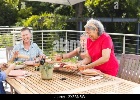 Diverse amiche anziane si godono un pasto all'aperto Foto Stock
