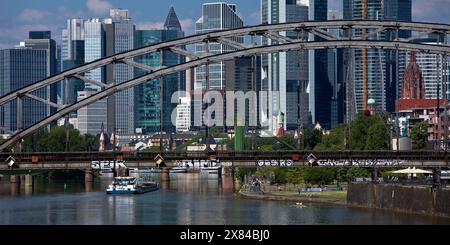 Il fiume meno con il ponte Deutschherrnbruecke e una chiatta di fronte allo skyline di Francoforte sul meno, Assia, Germania Foto Stock