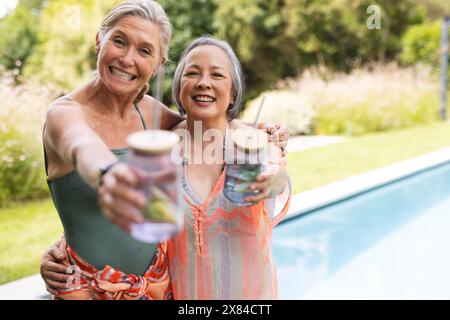 Diverse amiche anziane, sorseggiando un drink all'aperto Foto Stock