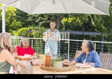 Diverse amiche anziane che condividono il pasto all'aperto Foto Stock