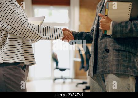 Primo piano di una donna d'affari che stringe il cliente di saluto in ufficio Foto Stock