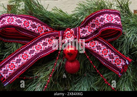 Fiocco di Natale rosso ricamato sui rami dell'albero di Natale Foto Stock