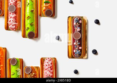 Assortimento di eclari francesi con smalti colorati e vari condimenti Foto Stock