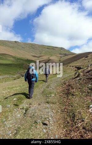 Due uomini (escursionisti) camminando sulla Wainwrights Coast fino al sentiero della costa da Grasmere a Patterdale nel Lake District National Park, Cumbria, Inghilterra, Regno Unito. Foto Stock