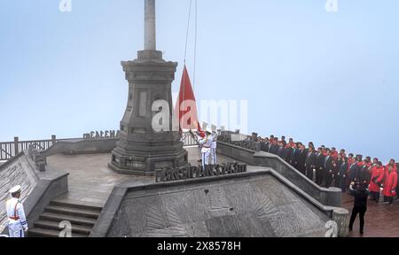 Picco del monte Fansipan, città di sa Pa, provincia di Lao Cai, Vietnam - 20 febbraio 2024: Guarda la cerimonia nazionale di innalzamento della bandiera sulla vetta del monte Fansipan Foto Stock