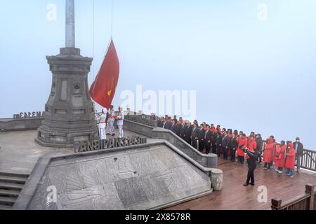 Picco del monte Fansipan, città di sa Pa, provincia di Lao Cai, Vietnam - 20 febbraio 2024: Guarda la cerimonia nazionale di innalzamento della bandiera sulla vetta del monte Fansipan Foto Stock