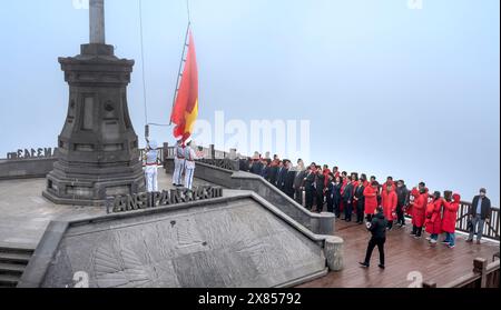 Picco del monte Fansipan, città di sa Pa, provincia di Lao Cai, Vietnam - 20 febbraio 2024: Guarda la cerimonia nazionale di innalzamento della bandiera sulla vetta del monte Fansipan Foto Stock