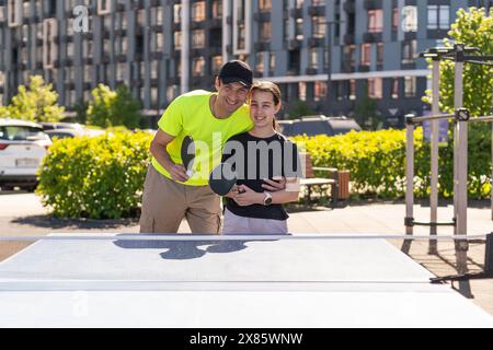 Felice uomo con sua figlia che gioca a ping pong nel parco Foto Stock