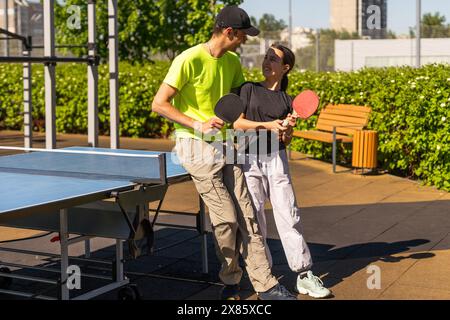 Felice uomo con sua figlia che gioca a ping pong nel parco Foto Stock