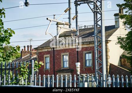 Il vecchio Railway Hotel dietro la linea elettrificata tra Preston e Blackpool, Regno Unito Foto Stock