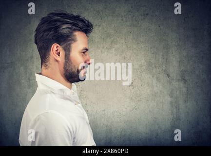Ritratto laterale di un bell'uomo allegro sorridente non rasato Foto Stock