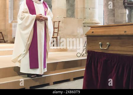 Un prete in una chiesa svolge un servizio funebre in una chiesa francese Foto Stock