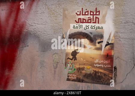 Beirut, Libano. 18 maggio 2024. Un poster raffigurante i parapendio di Hamas che si avvicinano alla Cupola della roccia (Qubbat a?-?A?ra) al complesso della moschea di al-Aqsa, Gerusalemme, nel campo profughi di Bourj el-Brajneh, Beirut, Libano, il 18 maggio 2024. Il testo arabo in alto recita: "Al-Aqsa Flood, la battaglia di tutti gli ummah (tutti i credenti musulmani). (Foto di Collin Mayfield/Sipa USA) credito: SIPA USA/Alamy Live News Foto Stock