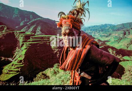 Filippine, Luzon; uomo della tribù Ifugao. Tradizionalmente vestito con piume in una fascia per la testa. Foto Stock