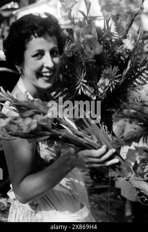 Porträt einer Blumenverkäuferin auf der Rambla im Zentrum von Barcelona, Spanien 1957. Ritratto di un venditore di fiori sulla Rambla nel centro di Barcellona, Spagna 1957. Foto Stock