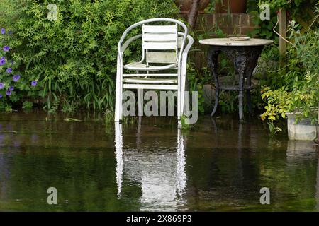 Eton Wick, Regno Unito. 23 maggio 2024. I residenti di Eton Wick, Windsor, Berkshire, che vivono vicino a Roundmoor Ditch sono sempre più preoccupati per i livelli di acqua alluvionale. Le inondazioni hanno iniziato a infiltrarsi in alcuni giardini del villaggio (nella foto). L'acqua del Tamigi può essere scaricata nel Roundmoor Ditch durante i periodi di forte pioggia e in numerose occasioni durante quest'anno si è verificata una vile puzza di acque reflue provenienti dal torrente, che all'inizio di quest'anno era pieno di funghi marini. I residenti, i consiglieri locali e gli ambientalisti chiedono all'Agenzia per l'ambiente e al Tamigi Water to ta Foto Stock