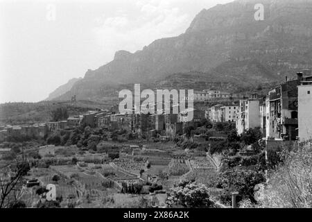 Blick über Monistrol de Montserrat, im Vordergrund landwirtschaftlich betriebene Felder, im Hintergrund die silhouette des Montserrat, Katalonien 1957. Ammira il Monistrol de Montserrat, i campi agricoli in primo piano, la silhouette di Montserrat sullo sfondo, Catalogna 1957. Foto Stock