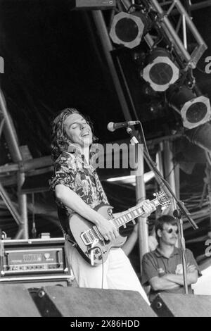 THE FAMILY CAT, GLASTONBURY FESTIVAL, 1992: Paul Frederick (AKA Fred) della Family CA suona una chitarra Gibson sul NME Stage al Glastonbury Festival, Pilton Farm, Somerset, Inghilterra il 28 giugno 1992. Foto: ROB WATKINS. INFO: I Family Cat, una band indie rock britannica della fine degli anni '80 e dell'inizio degli anni '90, offrirono un mix distintivo di alternative e shoegaze. Il loro suono energico, incarnato in album come "Tell 'Em We're Surfin', ha contribuito al vibrante paesaggio musicale della loro epoca. Foto Stock