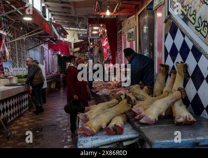 Meknes, Marocco - 5 marzo 2024: Vicolo interno con macellai che vendono carne fresca nel mercato della città vecchia di Meknes Foto Stock