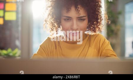 Primo piano Ritratto di una bella donna araba multietnica con occhi marroni e capelli ricci. Allegra giovane donna con un grande sorriso che gode di vita, successo e empowerment. Foto Stock