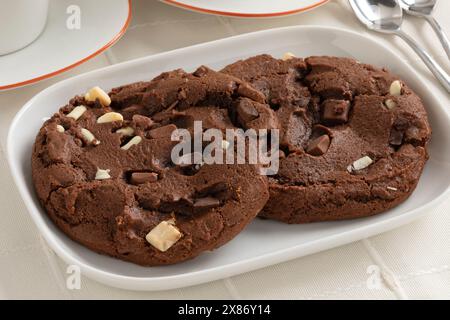 Piatto con un paio di dolci biscotti fatti in casa con scaglie di cioccolato americano da vicino Foto Stock