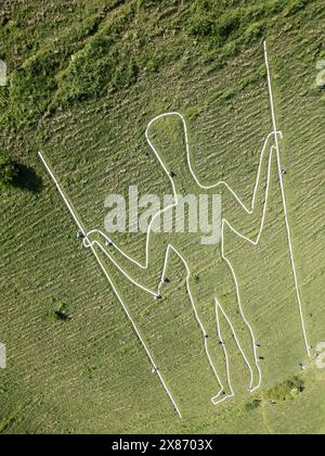 Wilmington, East Sussex, Regno Unito, 23/05/2024, Volunteers Below Paint the Long Man of Wilmington. La figura gigante sui ripidi pendii di Windover Hill è alta 72 metri e contiene due grondaie. Originariamente ritenuto neolitico, si pensa che sia ora del XVI o XVII secolo. La riverniciatura è il finale di una campagna di raccolta fondi a sostegno del lavoro della Sussex Archaeology Society (commerciale come Sussex Past), che possiede e si prende cura dell’iconica figura collinare nota come «The Guardian of the South Downs». La campagna ha raccolto oltre 10.000 sterline e ha visto quasi 300 donatori pagare 30,00 sterline per adottare uno dei 770 blocchi Foto Stock