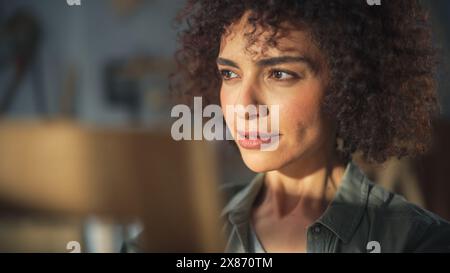 Giovane ed elegante falegname donna che assembla una sedia di legno. Designer di mobili professionale che lavora in uno studio in un loft con strumenti sulle pareti Foto Stock