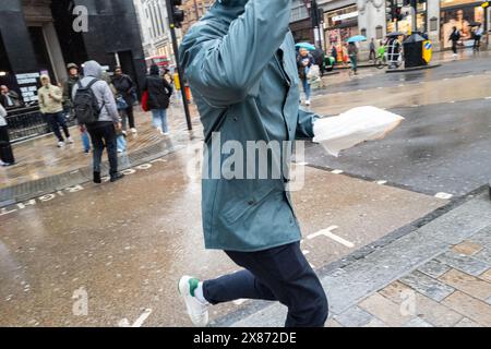 Uomo con pranzo in mano corre attraverso una strada di Londra, Regno Unito Foto Stock