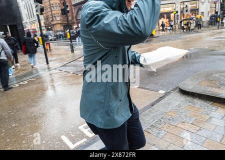 Uomo con pranzo in mano corre attraverso una strada di Londra, Regno Unito Foto Stock