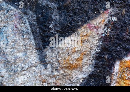 Frammento astratto di un vecchio muro di cemento dipinto con vernice lucida nera e argento. Foto Stock