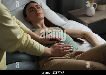 Doula lavora con donne incinte al chiuso. Preparazione alla nascita del bambino Foto Stock