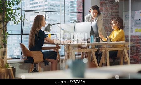 I colleghi creativi e multiculturali collaborano a un progetto e lavorano insieme come team. Marketing Manager e Designer discutono e discutono dei cambiamenti apportati a una campagna pubblicitaria per un'avvio. Foto Stock