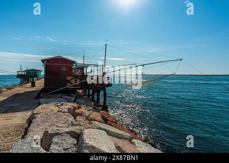 Vecchie capanne da pesca in legno e ferro con reti disposte per la pesca sulle dighe portuali vicino a Malamocco vicino ai murazzi al Lido di Venezia in Veneto Foto Stock