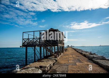 Vecchie capanne da pesca in legno e ferro con reti disposte per la pesca sulle dighe portuali vicino a Malamocco vicino ai murazzi al Lido di Venezia in Veneto Foto Stock