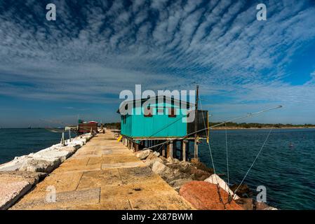 Vecchie capanne da pesca in legno e ferro con reti disposte per la pesca sulle dighe portuali vicino a Malamocco vicino ai murazzi al Lido di Venezia in Veneto Foto Stock