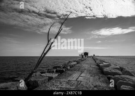 Vecchie capanne da pesca in legno e ferro con reti disposte per la pesca sulle dighe portuali vicino a Malamocco vicino ai murazzi al Lido di Venezia in Veneto Foto Stock