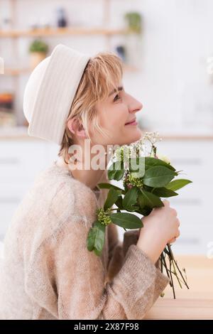Donna sorridente con bouquet di fiori Foto Stock