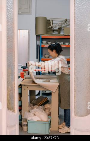 Ceramista che lavora a tavola in un laboratorio d'arte Foto Stock