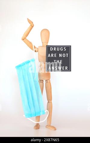 Un uomo ha una maschera blu accanto a un cartello leggere le droghe non sono la risposta, difendendo l'abuso di sostanze. Foto Stock