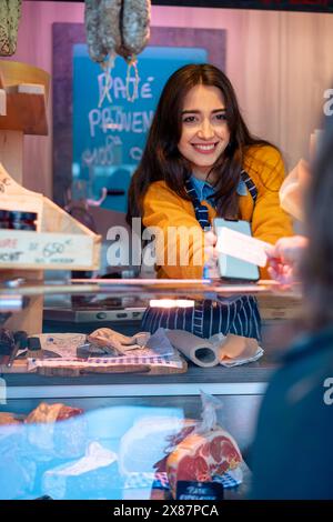 Fornitore sorridente che accetta il pagamento tramite il metodo di pagamento tap-to-pay dal cliente in negozio Foto Stock