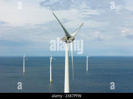 Turbine eoliche in mare sotto il cielo nuvoloso Foto Stock