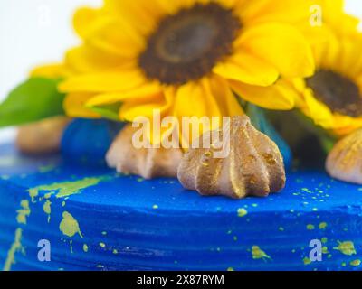 Splendida torta adornata con girasoli freschi e glassa blu vivace, perfetta per le celebrazioni e per aggiungere un tocco di colore a qualsiasi evento Foto Stock