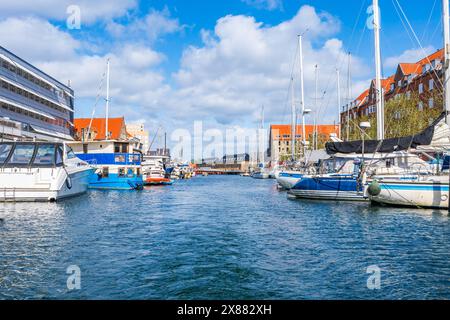 Vista del lungomare nel quartiere Christianshavn di Copenaghen con barche e yacht ormeggiati lungo un argine del canale. Danimarca Foto Stock